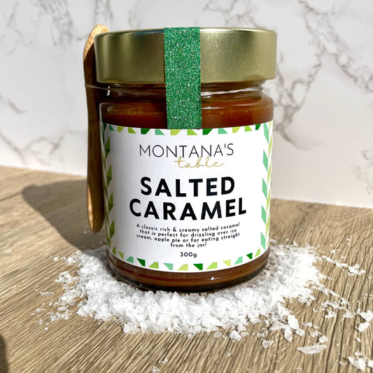 Montana's Table Salted Caramel Sauce jar on a wooden board with salt