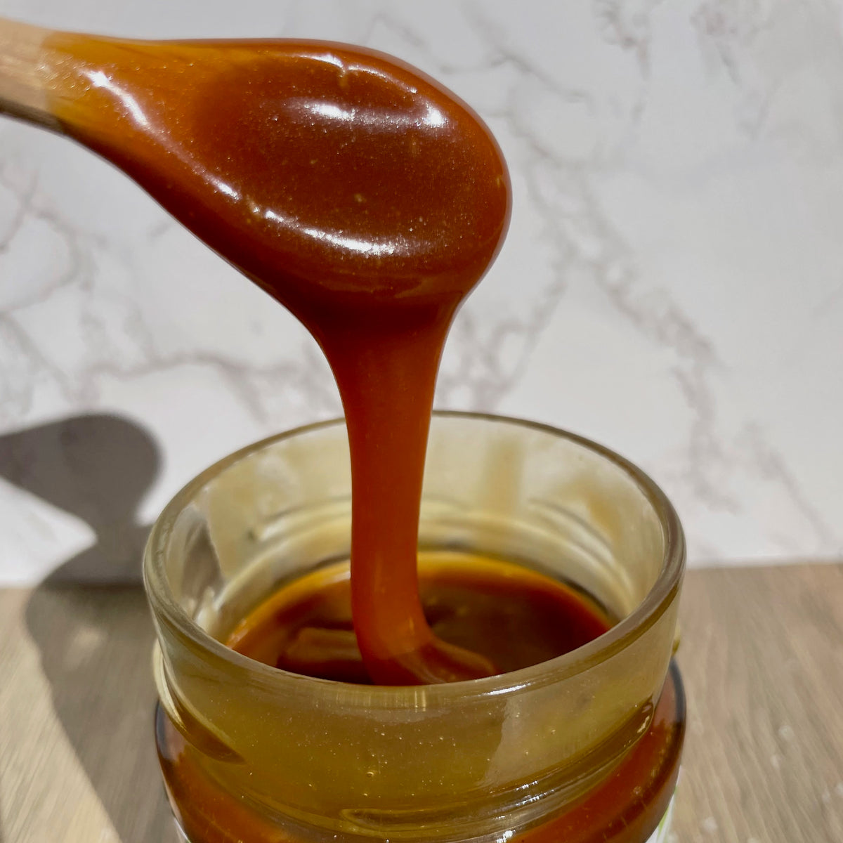 Thick Salted Caramel Sauce pouring into a jar, Montana's Table